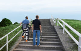 a person wearing a lifeward exoskeleton walking up the stairs.