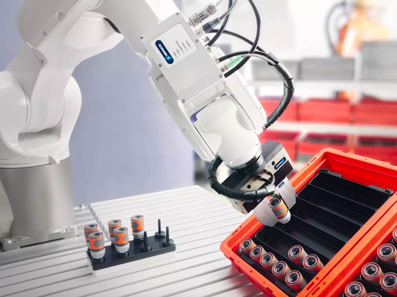 SCHUNK pneumatic positioning device connected to a robot arm picking up workpieces